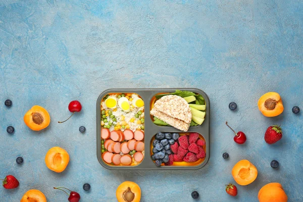 School lunch box with tasty food on color background