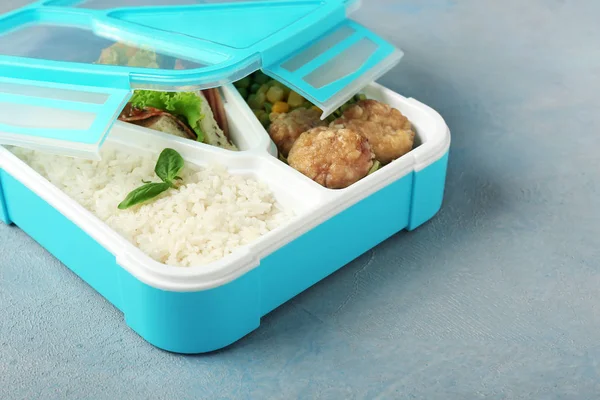 School lunch box with tasty food on color background