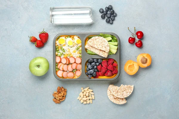 School lunch box with tasty food on color background — Stock Photo, Image