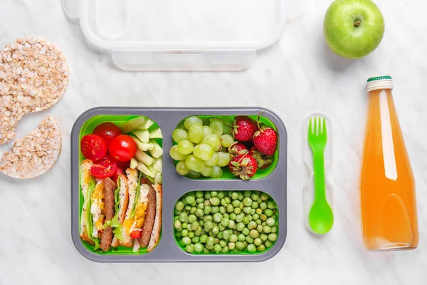 School lunch box with tasty food and juice on light background — Stock Photo, Image