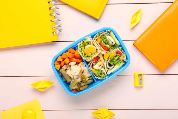 Schulessenbox mit leckerem Essen und Schreibwaren auf dem Tisch — Stockfoto