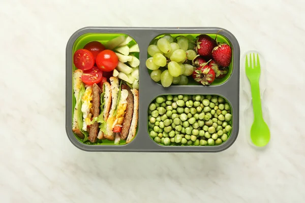 Schoollunchbox met lekker eten op lichte achtergrond — Stockfoto