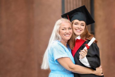 Mezuniyet gününde annesi ile mutlu genç kadın