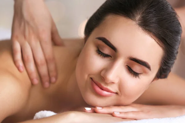 Beautiful young woman receiving massage in spa salon — Stock Photo, Image