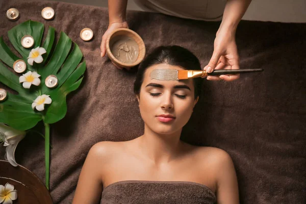 Cosmetologo applicare maschera sul viso della donna nel salone spa — Foto Stock