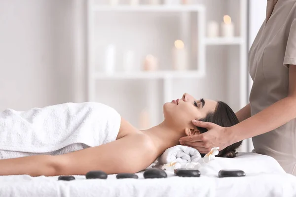 Beautiful young woman receiving massage in spa salon — Stock Photo, Image