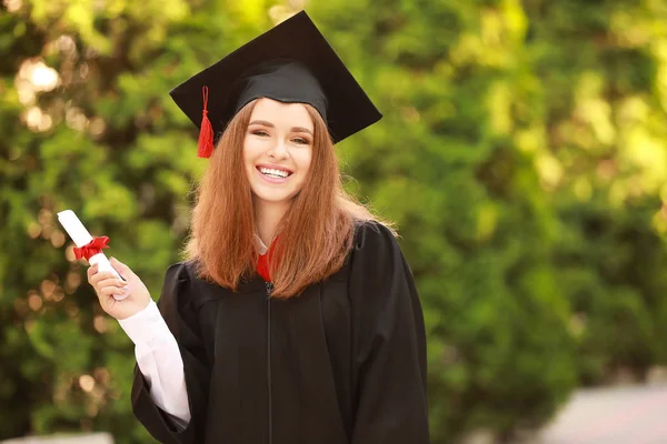 Mujer joven feliz con diploma en el día de la graduación — Foto de Stock