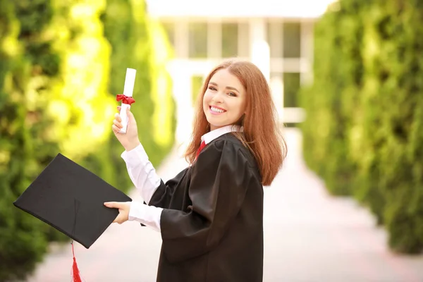 Mujer joven feliz con diploma en el día de la graduación — Foto de Stock