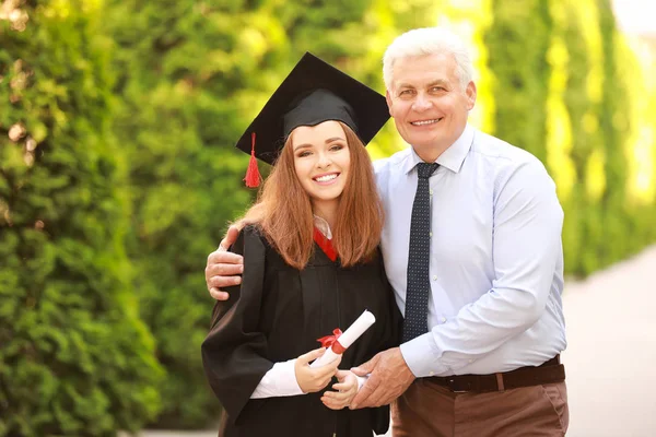 Lycklig ung kvinna med sin far på examensdagen — Stockfoto