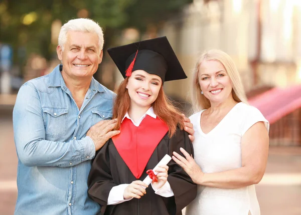 Happy young woman with her parents on graduation day — Stock Photo, Image