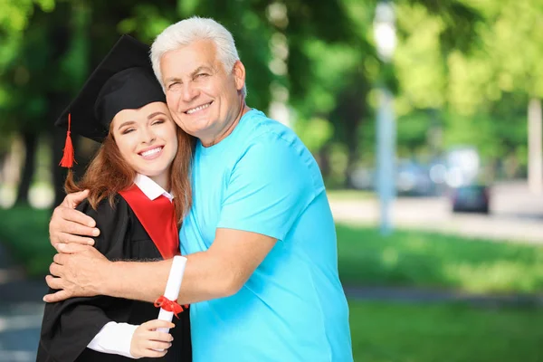 Lycklig ung kvinna med sin far på examensdagen — Stockfoto