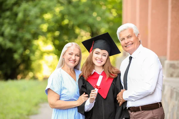 Feliz joven con sus padres en el día de la graduación — Foto de Stock