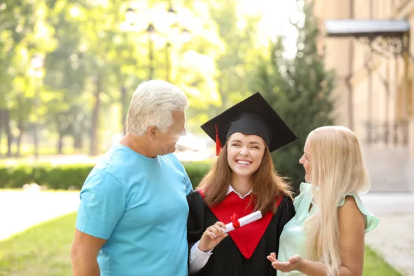 Lycklig ung kvinna med sina föräldrar på examensdagen — Stockfoto