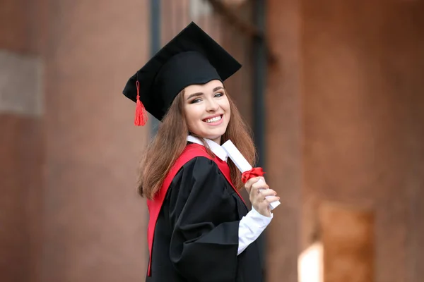 Šťastná mladá žena s diplomem v den promoce — Stock fotografie