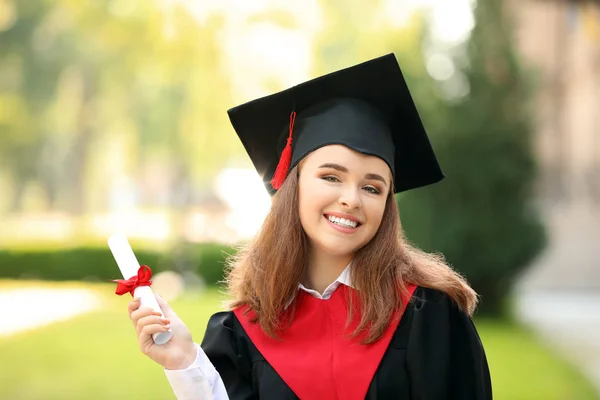 Счастливая молодая женщина с дипломом в день выпуска — стоковое фото