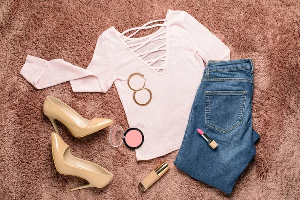 Stilvolle weibliche Optik mit Jeans-Kleidung auf farbigem Hintergrund — Stockfoto