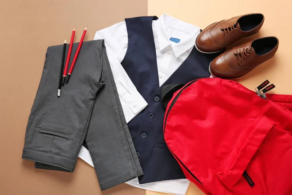色の背景にバックパックとスタイリッシュな学校の制服 — ストック写真