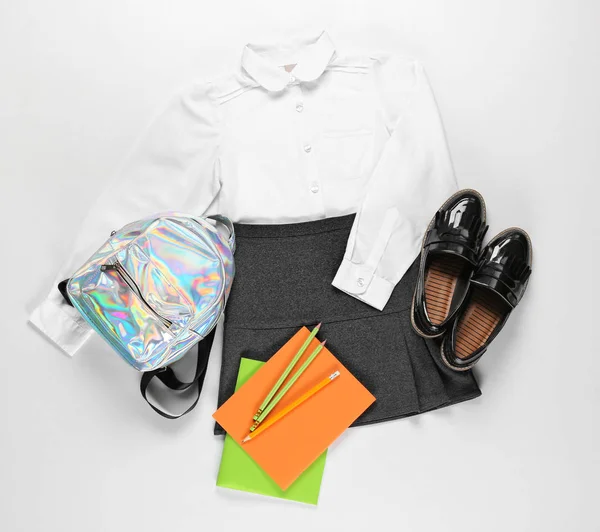 Стильная школьная форма с рюкзаком и канцелярскими принадлежностями на белом фоне — стоковое фото