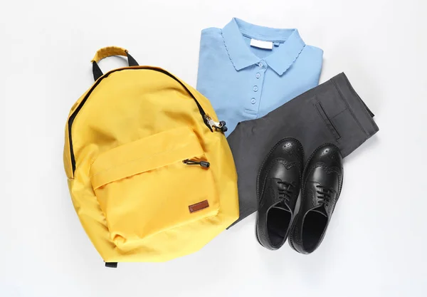 Beyaz arka planda sırt çantası olan şık bir okul üniforması. — Stok fotoğraf