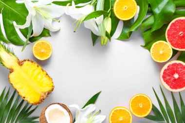 Renkli arka planda farklı meyve ve tropikal yapraklardan yapılmış çerçeve