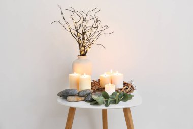 Okaliptüs ve vazo ile güzel yanan mumlar ışık arka plan karşı masada dalları ile