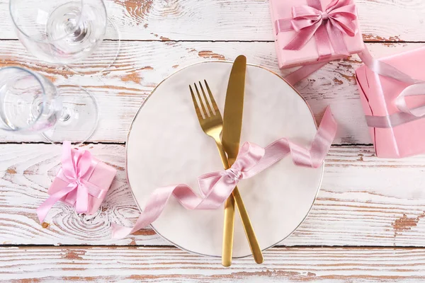 Beautiful table setting with gift boxes on white wooden background — Stock Photo, Image