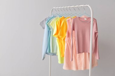 Hafif arka plana karşı rafta asılı şık çocuk giysileri