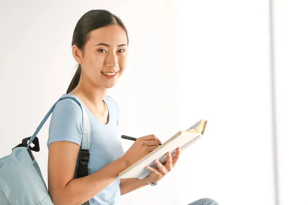 Jonge Aziatische student voorbereiding voor examen in de buurt van venster — Stockfoto