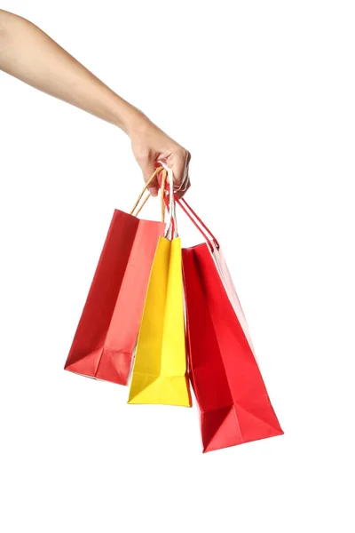 Mão feminina com sacos de compras no fundo branco — Fotografia de Stock