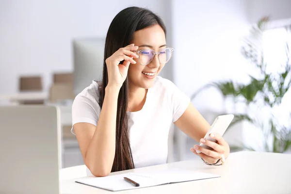 Jeune étudiant asiatique utilisant un téléphone portable tout en se préparant à l'examen — Photo