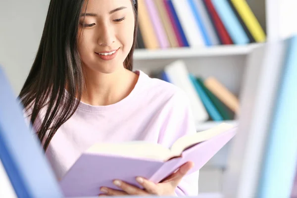 Joven estudiante asiático eligiendo libros en la biblioteca —  Fotos de Stock