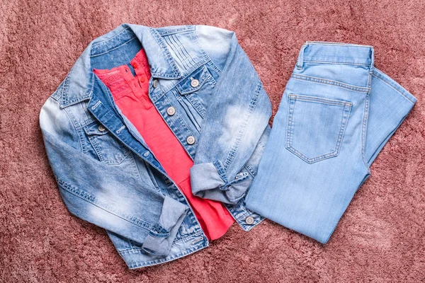 色の背景にジーンズの服でスタイリッシュな子供の外観 — ストック写真