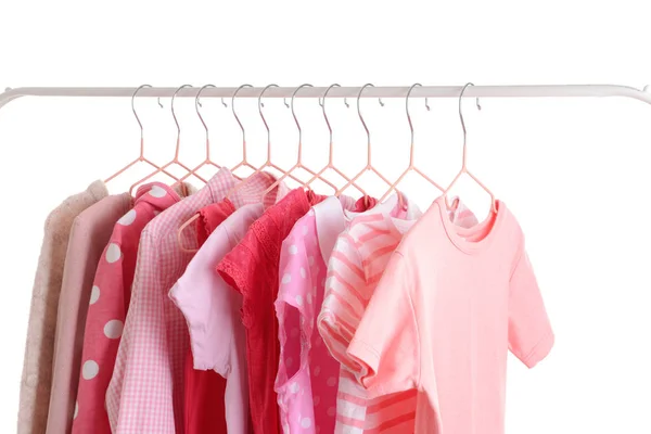 Snygga barnkläder hängande på rack mot vit bakgrund — Stockfoto