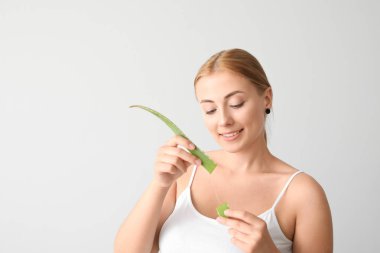 Hafif arka planda aloe vera ile güzel genç kadın