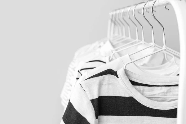Κομψά ρούχα για παιδιά κρέμονται σε rack κατά φως φόντο — Φωτογραφία Αρχείου
