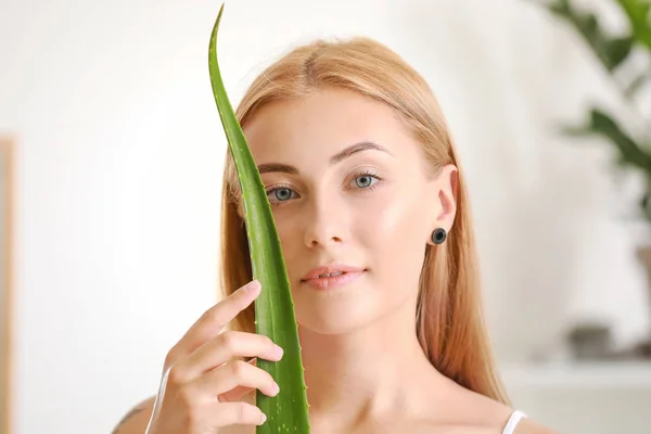 Beautiful young woman with aloe vera at home — Stock Photo, Image