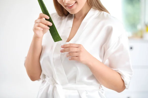 Mulher bonita usando cosméticos com extrato de aloe vera em casa — Fotografia de Stock