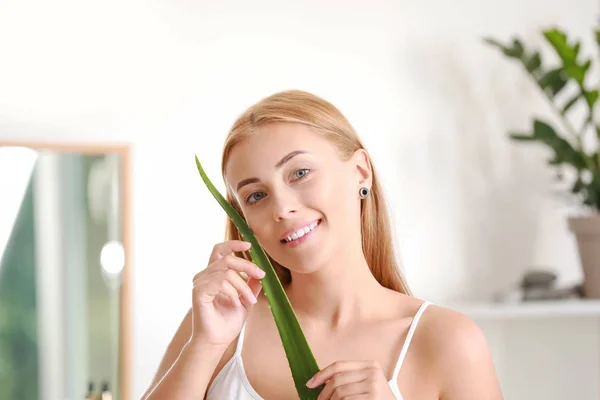 Beautiful young woman with aloe vera at home — Stock Photo, Image