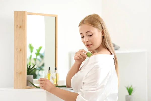 Beautiful young woman using aloe vera at home — Stock Photo, Image