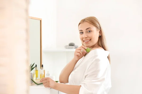 Beautiful young woman using aloe vera at home — Stock Photo, Image