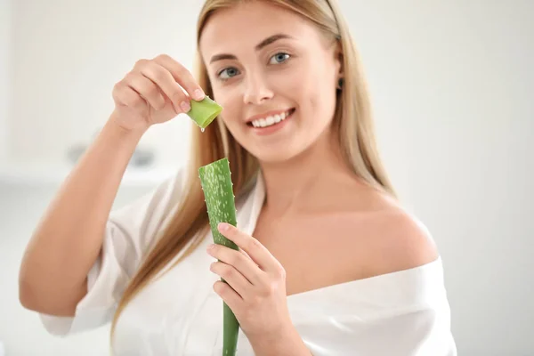 Beautiful young woman using aloe vera at home — Stock Photo, Image