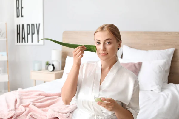 Beautiful young woman using aloe vera at home — Stock Photo, Image