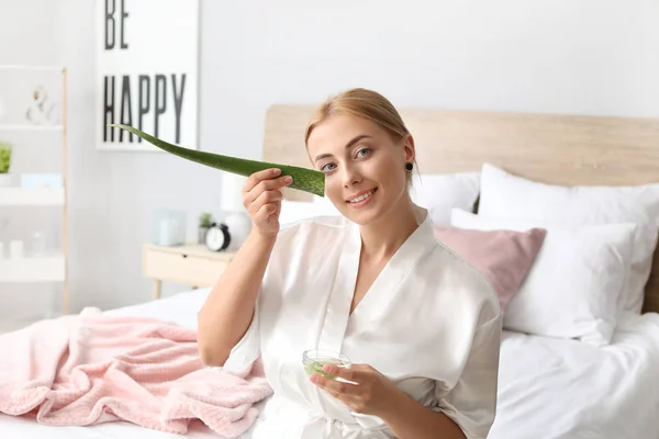 Beautiful young woman using aloe vera at home — Stock Photo, Image