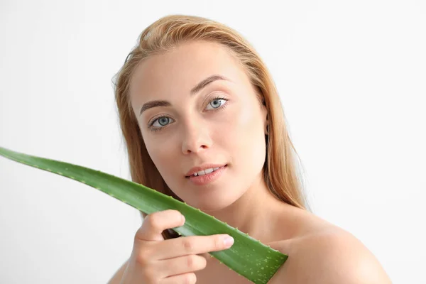 Beautiful young woman with aloe vera on color background — Stock Photo, Image