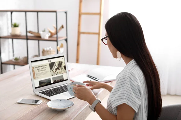 Asian blogger with laptop at table — Stock Photo, Image