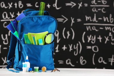 Sınıfta masada kırtasiye ile Okul sırt çantası