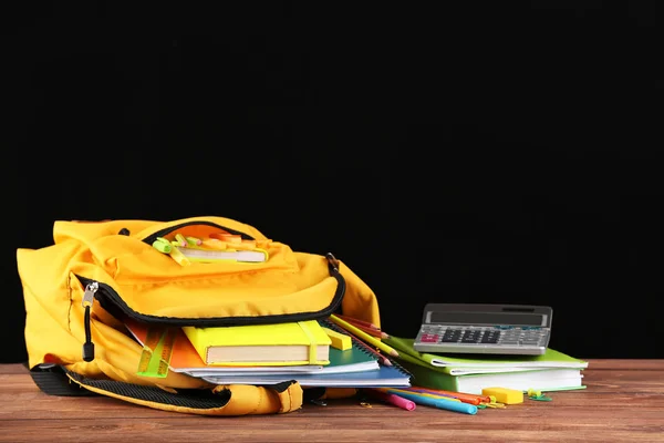 Mochila escolar con papelería en la mesa en el aula —  Fotos de Stock