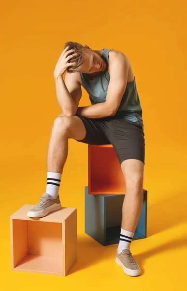 Стильный молодой человек в спортивной одежде на цветном фоне — стоковое фото