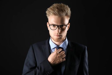 Koyu arka plan üzerinde resmi giysiler şık genç adam