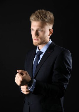 Koyu arka plan üzerinde resmi giysiler şık genç adam